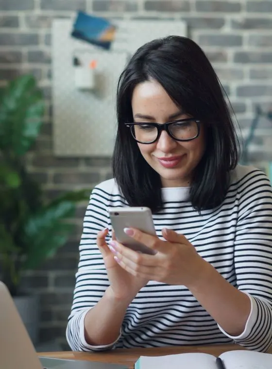 A real estate agent checking her phone expectantly as her AI visibility rises